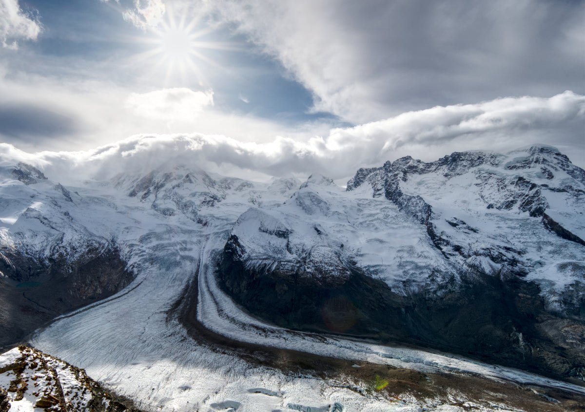 Fine Art Print Blick auf den Gornergletscher mit dramatischer Wolkendecke und Sonnenstern zwischen den Wolken