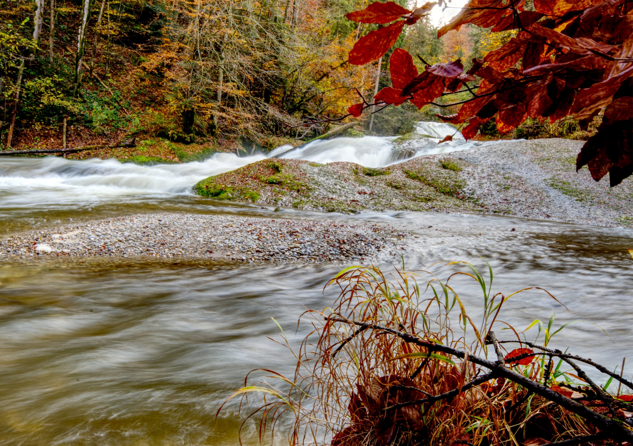 Fine Art Print einer Langzeitbelichtung eines Wasserfalls in der Wutachschlucht im Schwarzwald mit Blick unter einem Ast hervor